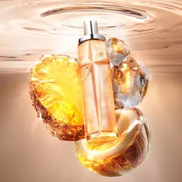 New Starlicious Pineapple Musk still life featuring the slender glass bottle surrounded by its key ingredients: a glowing pineapple slice, a cracked coconut shell, and crystalline musk, all set against a warm, luminous rippling water background.