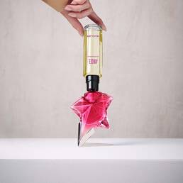 Refilling a pink Angel Nova star perfume bottle with a yellow refill bottle held upside down