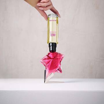 Refilling a pink Angel Nova star perfume bottle with a yellow refill bottle held upside down