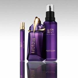 Mugler Alien perfume bottle with refill bottle and travel spray on reflective surface