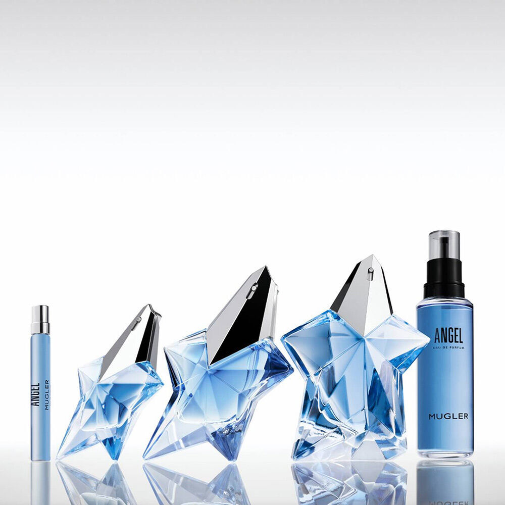 Angel Mugler travel spray, two blue star bottles, and refill bottle on a reflective surface