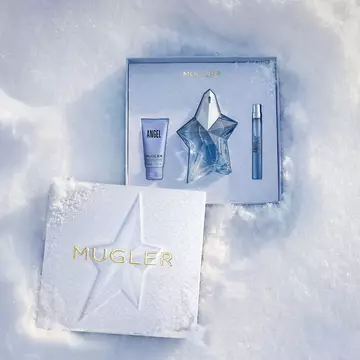An open, textured ice-blue glistening Mugler gift set resting on snow, revealing an angel eau de parfum 100ml gift set