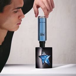 Man inserting A*Men Eau de Toilette blue refill bottle into black fragrance bottle.
