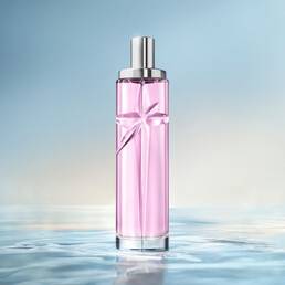Starlicious Berry Licorice still life: slender glass bottle with strawberry, raspberry, pink flower and black licorice sticks on a soft pink rippling water background.