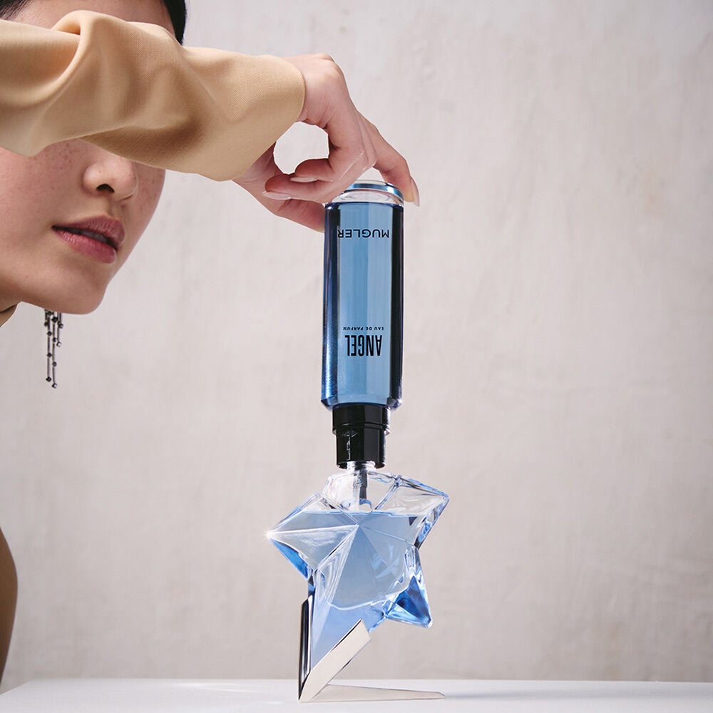 Refilling an Angel Mugler star perfume bottle with a blue refill bottle held upside down​