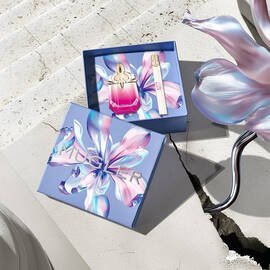 Mugler Mother's Day 2026 gift box with a kaleidoscopic floral pattern, containing the Alien Pulp perfume set on a sunlit stone surface with a concrete crack.