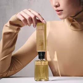 Model refilling an Alien Goddess perfume bottle with a matching refill bottle