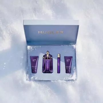 An open, textured ice-blue glistening Mugler gift set resting on snow, revealing an alien eau de parfum 60ml luxury gift set