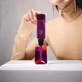 Model refilling Alien bottle from matching purple refill vial