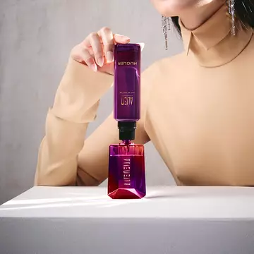 Model refilling Alien bottle from matching purple refill vial