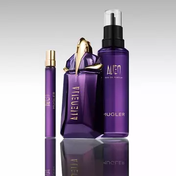 Mugler Alien perfume bottle with refill bottle and travel spray on reflective surface