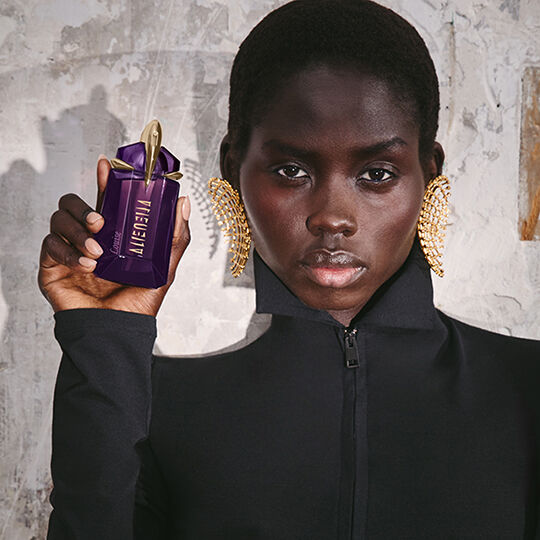 model holding engraved bottle of Alien by Mugler