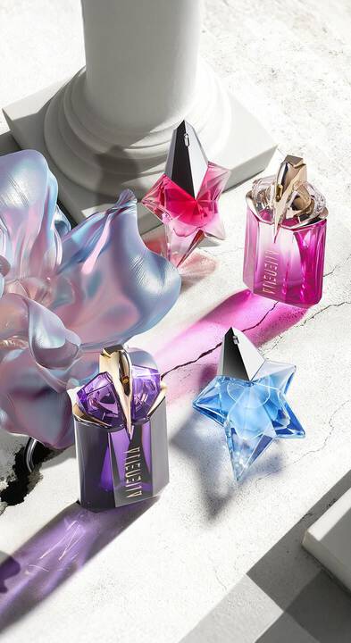 Mugler Mother's Day 2026 campaign banner featuring the iconic Angel and Alien franchise perfume bottles in a celestial floral and Parisian landscape, celebrating extraordinary mothers.