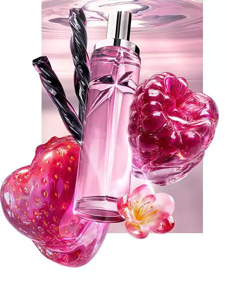 New Starlicious Berry Licorice still life featuring the slender glass bottle surrounded by its key ingredients: a glossy red strawberry, a vibrant raspberry, a delicate pink flower, and twisted black licorice sticks, all set against a soft pink rippling water background.