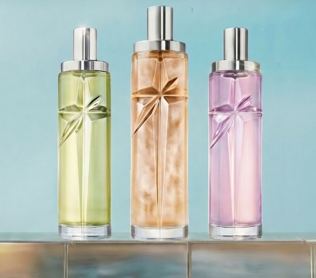 Three Starlicious Mugler refill bottles in green, amber and soft pink displayed on a tiled pool edge against a luminous blue background.