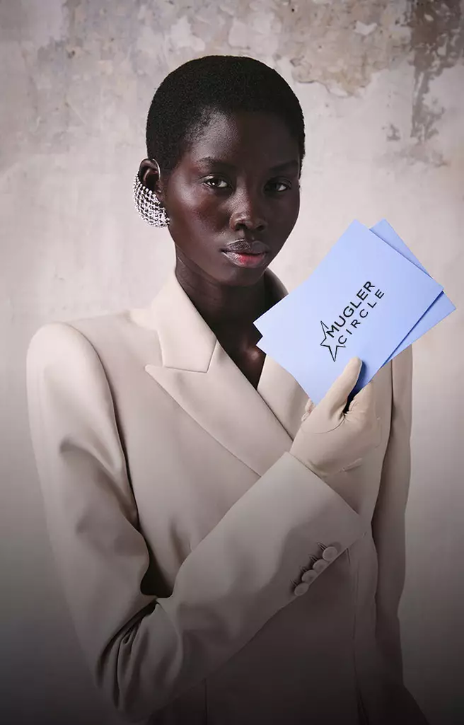 Model holding a Mugler birthday gift envelope and card.