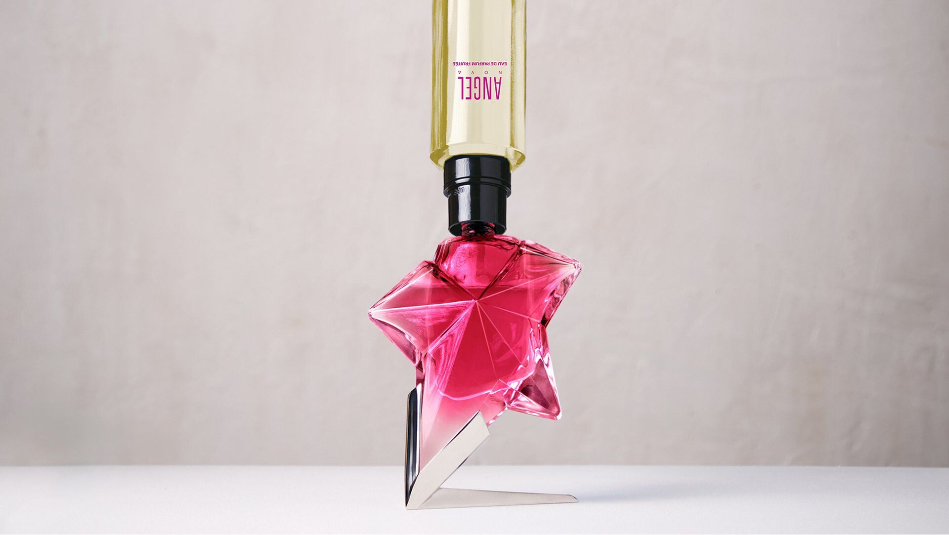 Angel Nova Eau de Parfum Fruitée refillable star-shaped pink bottle being filled from a refill flacon